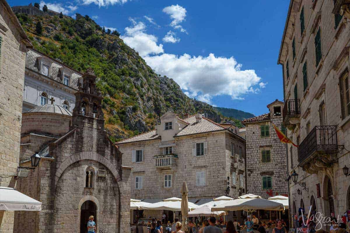 Typical stone buildings and churches beneath the mountainous landscape in the Old Town of Kotor. 